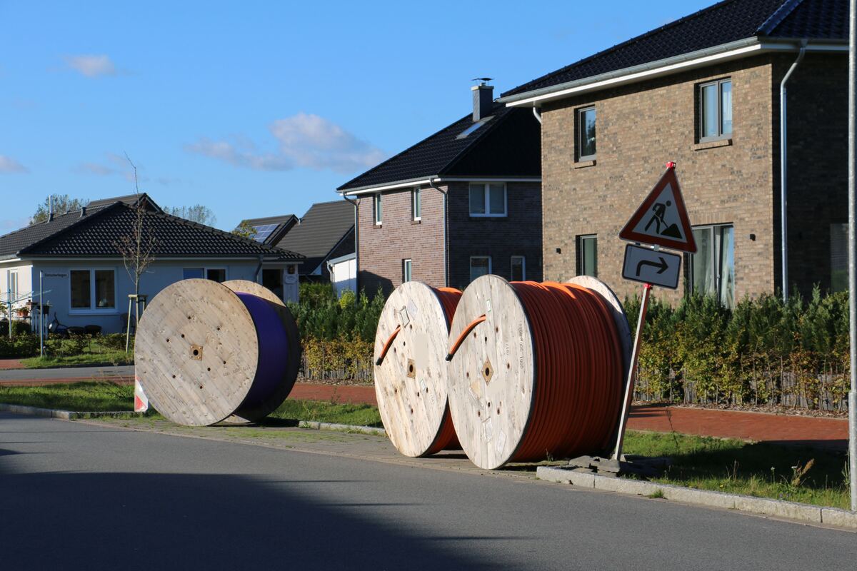 Kabelhaspels met buizen aan de rand van een woonstraat met bakstenen huizen
